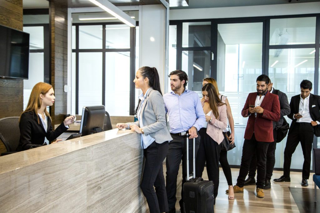 people lined up at a hotel front desk